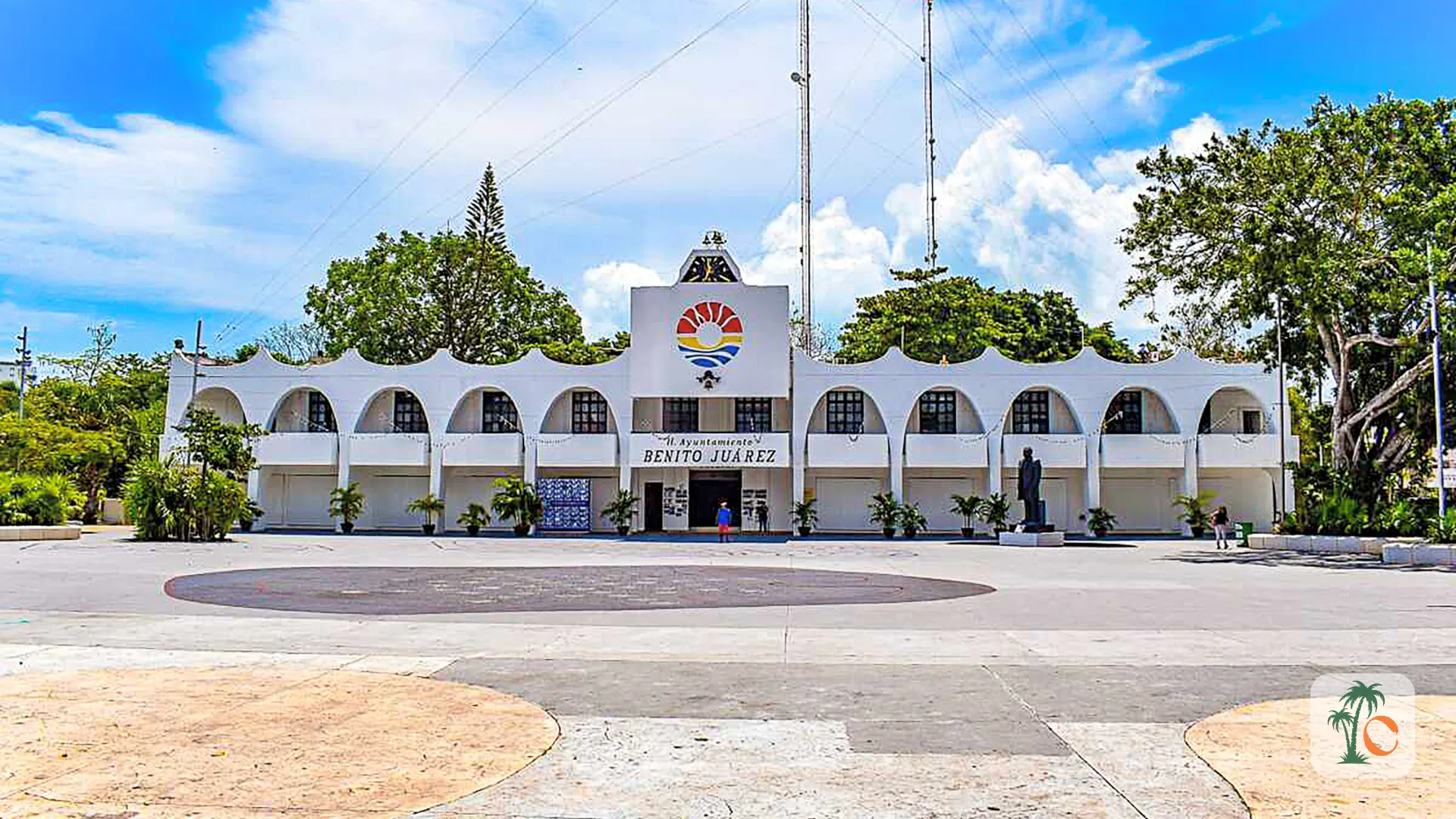 The main building of the Benito Juárez Municipal Government in Cancún, with a wide plaza in front and clear blue skies in the background.
Caption: